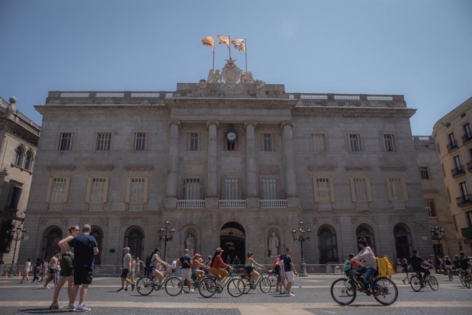 Archivo - Arxiu - Diverses persones caminen davant l'edifici de l'Ajuntament de Barcelona, a 1 d'agost de 2023