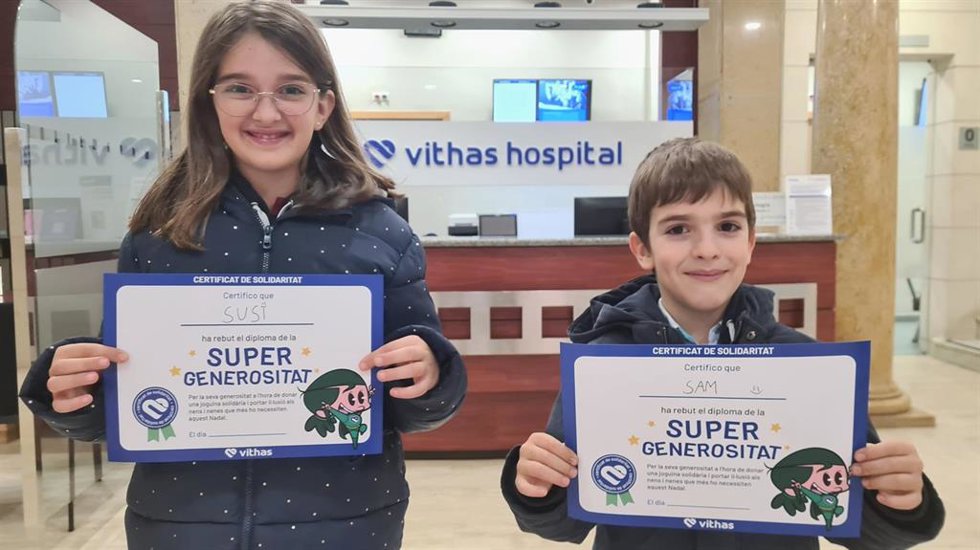 Dos niños con su diploma de 'Super Generosidad' tras donar un regarlo