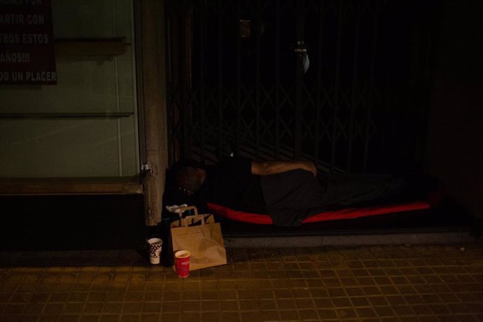 Archivo - Un hombre duerme en un portal en Barcelona.