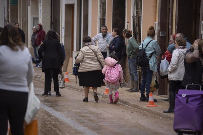 Una mujer y una niña a la salida del colegio 'La Inmaculada', el primero en abrir tras la DANA, a 4 de diciembre de 2024, en Paiporta, Valencia, Comunidad Valenciana (España). 