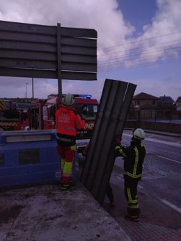 Bomberos sujetan un cartel en Treto