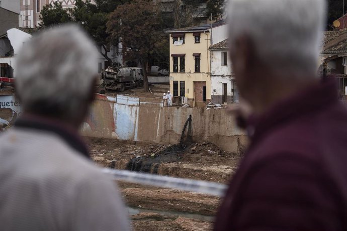 Dos personas durante la presentación de la Agrupación de Afectados por la DANA ‘Tots a Una Veu’, frente al barranco del Poyo, a 4 de diciembre de 2024, en Picanya, Valencia