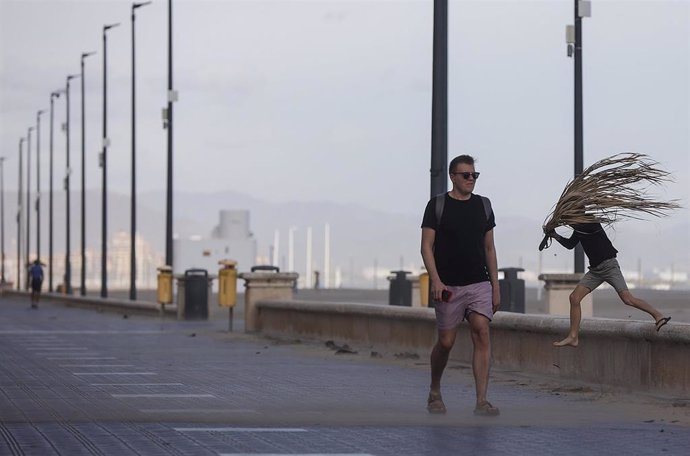 Archivo - Un hombre anda por el paseo de la playa de la Malvarrosa con fuertes rachas de viento