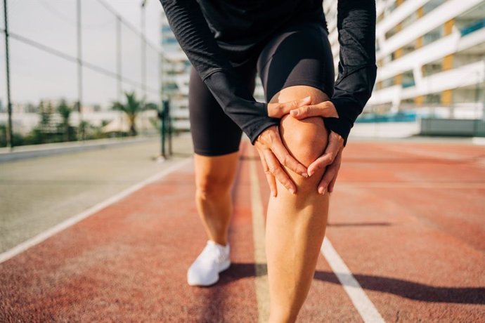 Archivo - Una persona se queja de dolor de rodilla al correr.