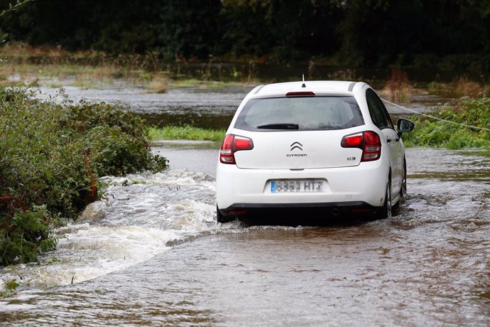 Archivo - Un coche circula por un camino anegado por el desbordamiento del río Anllo, a 9 de octubre de 2024, en A Veiga, Abadín, Lugo, Galicia (España). La Agencia Estatal de Meteorología (AEMET) ha puesto a Galicia en alerta naranja por la borrasca Kirk