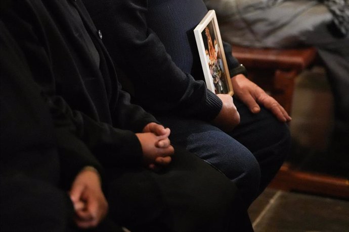 Un hombre sujeta una imagen durante la misa funeral por los fallecidos en las inundaciones provocadas por la DANA, en la Catedral de Valencia, a 9 de diciembre de 2024, en Valencia