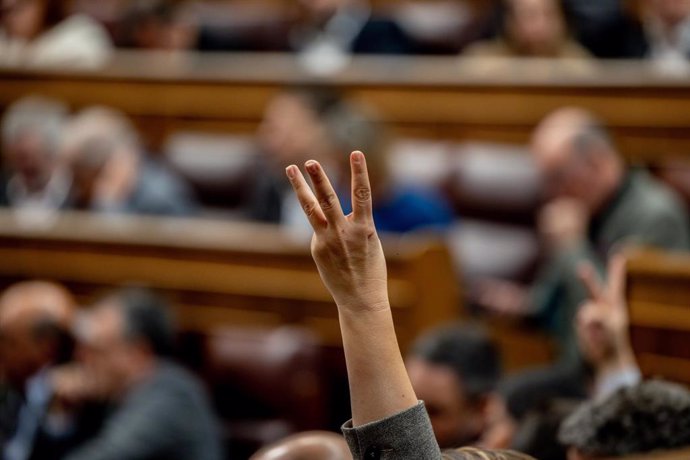 Una persona indica el número de votación durante una sesión plenaria en el Congreso