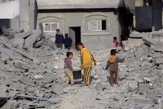 Un grupo de niños caminan entre las casas destruidas por bombardeos de Israel contra el campo de refugiados de Nuseirat, en el centro de  Gaza