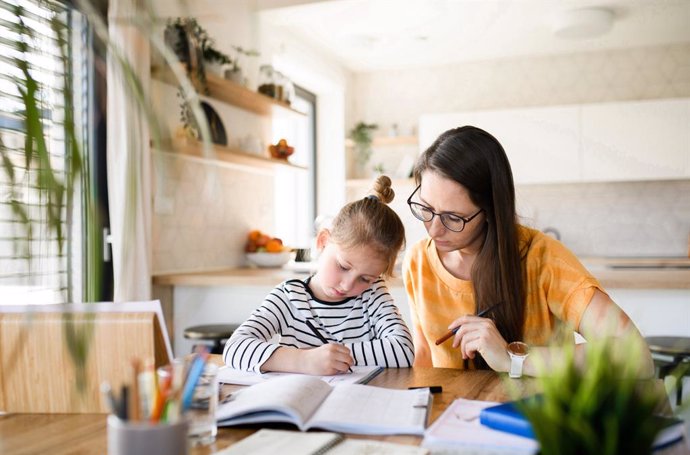 Archivo - Madre ayuda a su hija a estudiar.