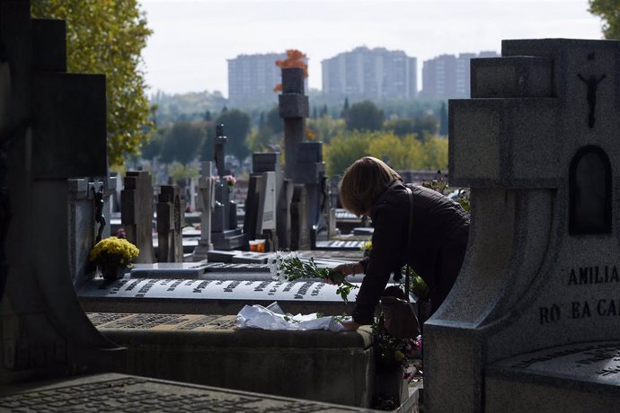 Archivo - Una mujer lleva flores a un ser querido, en el Cementerio de la Almudena, a 1 de noviembre de 2024, en Madrid (España). Este año, los cementerios de Madrid han ampliado su horario y han reforzado su servicio de limpieza, jardinería y vigilancia 