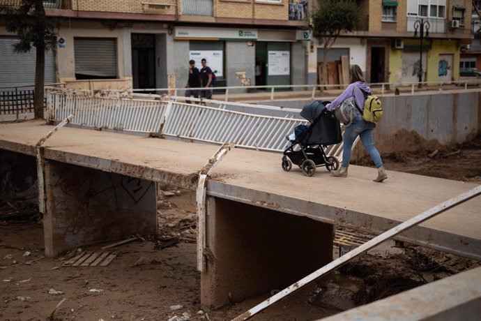 Una mujer con un silla de un niño cruza un puente de Aldaia (archivo)