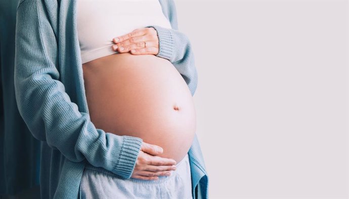 Archivo - Una mujer embarazada se toma las manos en el vientre. Concepto de embarazo, maternidad, preparación y expectativa