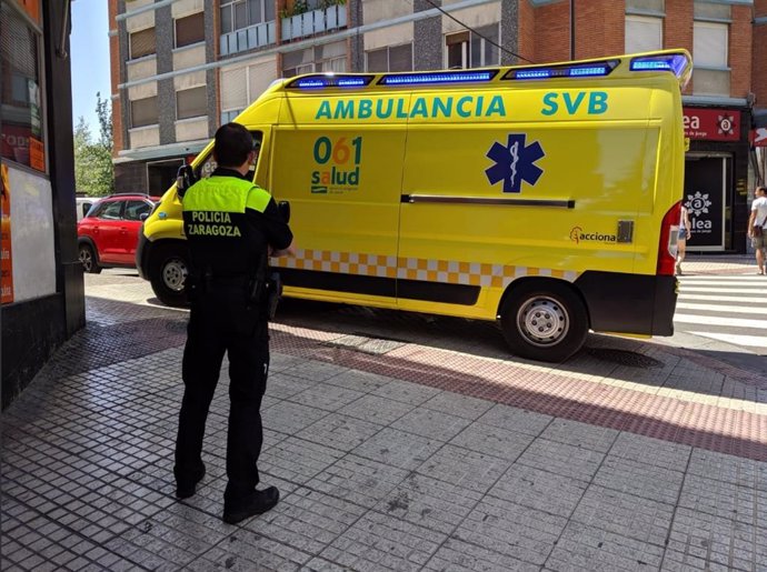 Archivo - Un oficial de la Policía de Zaragoza junto con una ambulancia del 061.