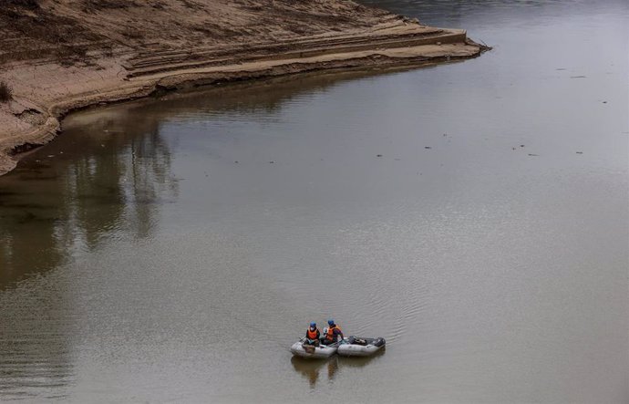 Una lancha trabaja para limpiar el agua tras el efecto de la dana en la presa de Buseo