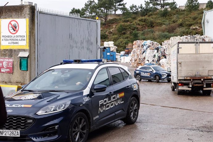 Varios coches de la Policía Nacional en el lugar donde se halló un cadáver en un contenedor de cartón 