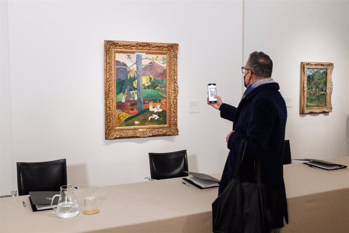 Archivo - Un hombre fotografía la obra 'Mata Mua' de Paul Gauguin, durante la firma del contrato de alquiler de la Colección Carmen Thyssen-Bornemisza, en el Museo Nacional Thyssen- Bornemisza, a 9 de febrero de 2022.