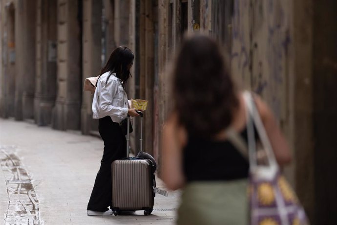 Archivo - Dos turistas con maletas en el centro de Barcelona, en una imagen de archivo.