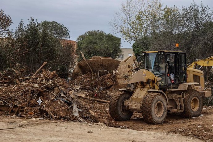 Una máquina excavadora trabaja en las inmediaciones del lugar donde han hallado el cuerpo de una víctima de la dana, a 12 de diciembre de 2024, en Paiporta (Valencia).