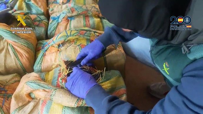 Un agente de la Guardia Civil con parte de la droga incautada en Huelva.