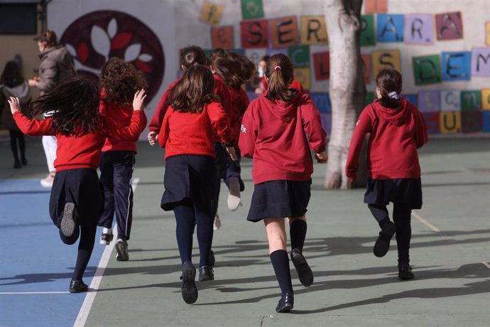 Archivo - Un grupo de niños corren en el patio de un colegio.