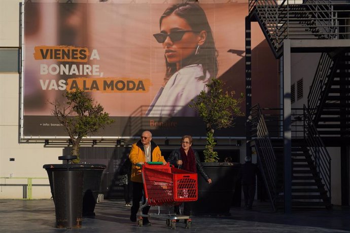 Dos personas salen de comprar en el Alcampo del centro comercial Bonaire, el primer día que han abierto algunas de las tiendas, a 13 de diciembre de 2024, en Valencia, Comunidad Valenciana (España). Algunos de los comercios ubicados en el centro comercial