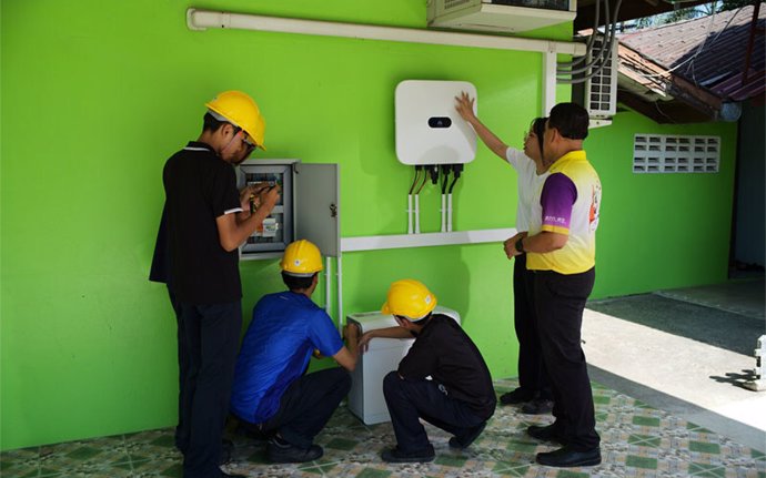 Huawei engineers instruct interns how to install the Huawei solar equipment at Banna District Learning Encouragement Center