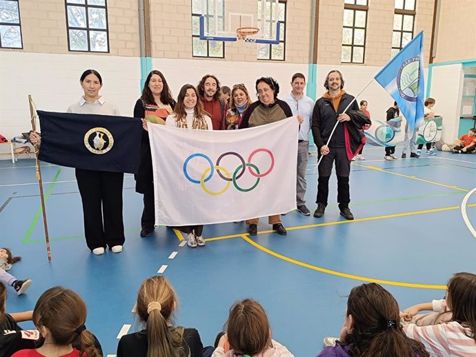 Representantes del colegio Gadir reciben la bandera olímpica de manos de integrantes del Tierno Galván