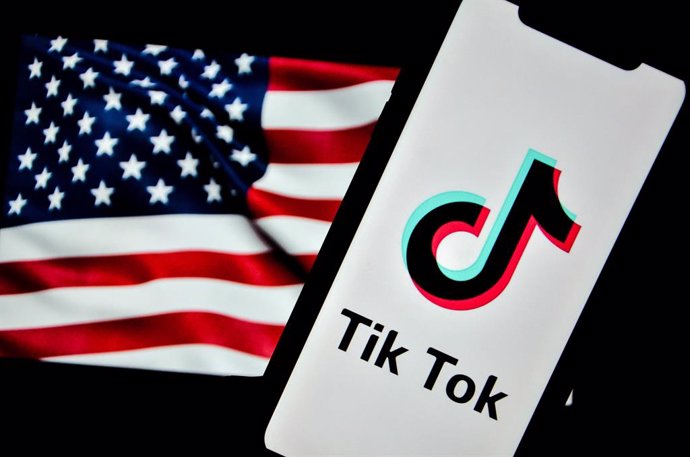 December 8, 2024: Tunis, Tunisia. 08 December 2024. In this photo illustration, the TikTok logo is displayed on an iPhone screen with the U.S. flag in the background. The U.S. Court of Appeals in Washington D.C. has upheld the law forcing China-based Byte