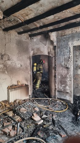 Bomberos de la DPT en el interior de la vivienda que se ha incendiado este domingo en la localidad turolense de Albalate del Arzobispo.