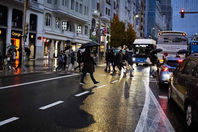 Archivo - Transeúntes caminan por Gran Vía, cerca de una zona comercial de la calle de Preciados