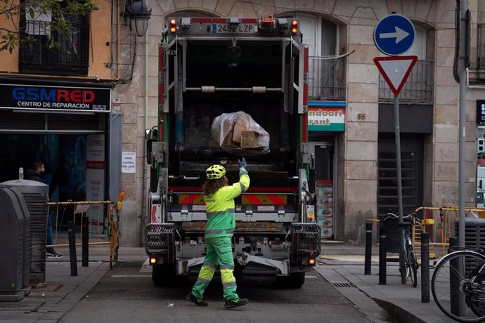 Una persona del servicio municipal de limpieza recoge basura, en el barrio del Raval, a 12 de diciembre de 2024, en Barcelona, Catalunya (España).