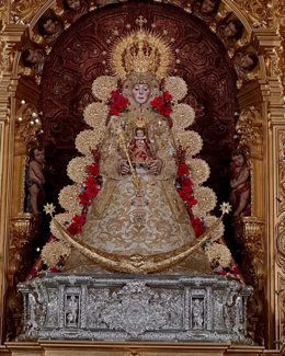 La Virgen del Rocío con un traje realizado en el Taller de Bordado de la Hermandad Matriz y con el manto rojo-buganvilla de brocados para celebrar la Navidad.