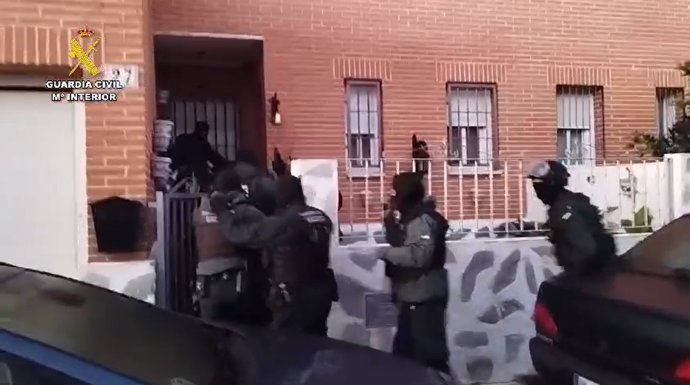 Agentes de la Guardia Civil irrumpen en una vivienda durante un registro.