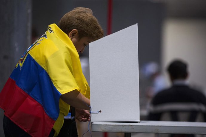 Archivo - April 21, 2024, Madrid, Spain: A woman with an Ecuadorian flag around her neck exercises her right to vote at one of the voting tables at the IFEMA fairgrounds in Madrid, during the referendum day in Ecuador. The Ecuadorian community registere