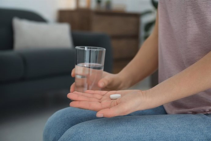 Archivo - Joven con píldora abortiva y vaso de agua en interior, primer plano