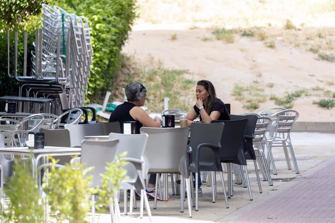 Archivo - Varias personas sentadas en una terraza.