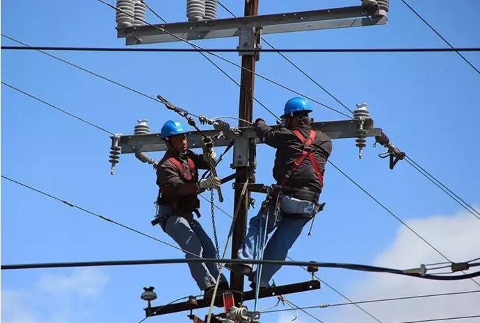 Archivo - Trabajadores en un poste telefónico