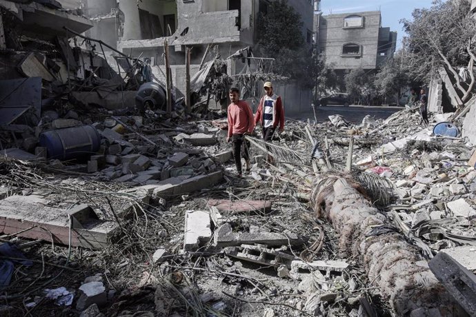 Palestinos entre edificios destruidos por los ataques del Ejército de Israel contra el campamento de refugiados de Bureij, en el centro de la Franja de Gaza (archivo)