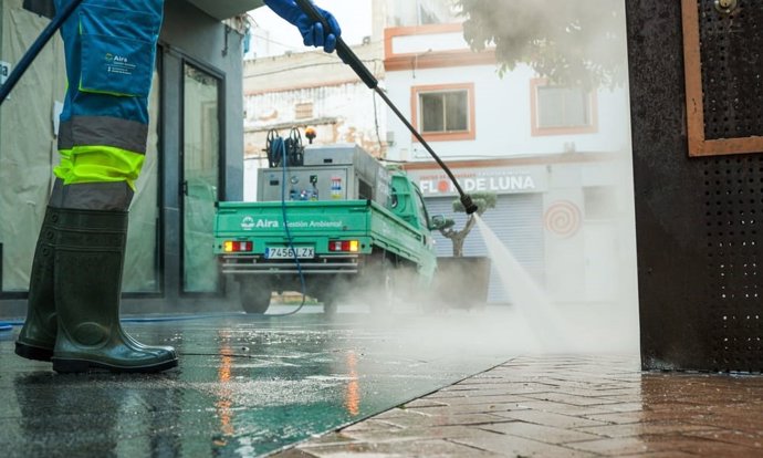 Detalle de un trabajador del servicio de la limpieza en plena labor de baldeo.