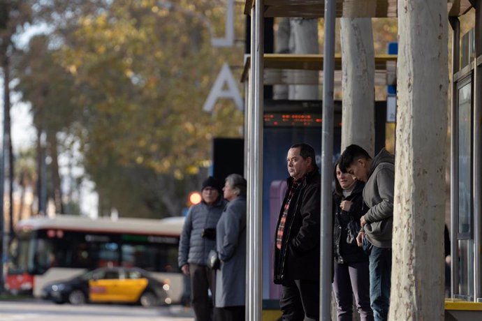 Varias personas esperan al autobús, a 13 de diciembre de 2024, en Barcelona, Catalunya (España).