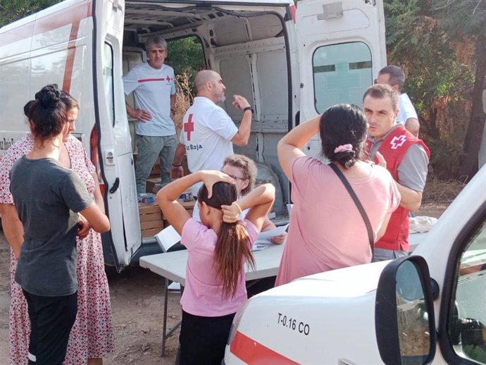 Voluntarios de Cruz Roja visitan un asentamiento.