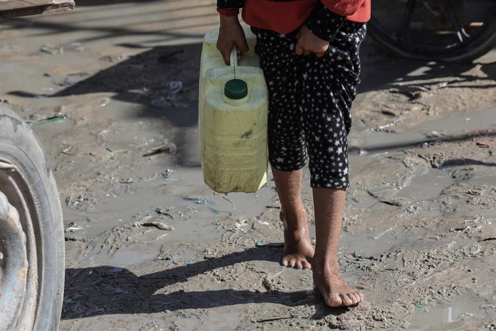 Archivo - Un niño con una garrafa esperando para conseguir agua potable en un punto de suministro en Deir al Balá, en la Franja de Gaza (archivo)