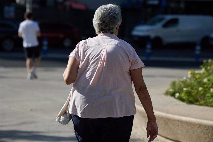 Archivo - Una mujer jubilada caminando por una calle de Madrid