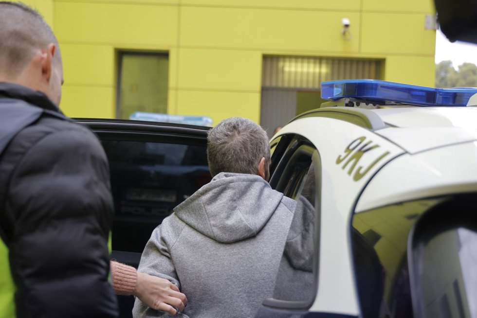 El detenido, esposado, se introduce en un vehículo de la Policía Nacional