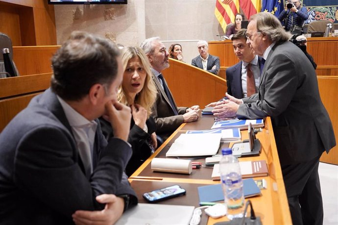 La portavoz del Gobierno de Aragón, Mar Vaquero, conversa con el consejero de Hacienda, Roberto Bermúdez de Castro, antes del inicio de la sesión plenaria de las Cortes autonómicas.