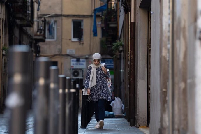 Archivo - Una mujer camina por una calle céntrica de Barcelona.