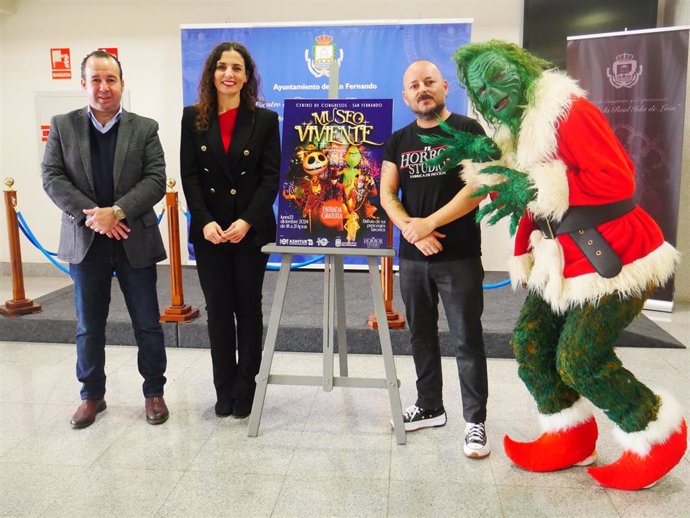 La concejala de Comercio en el Ayuntamiento de San Fernando, María Gómez, el vicepresidente de la Asociación Isleña de Hostelería y Turismo (Asihtur), Antonio Alba, y el gerente de Horror Studio FX, Joaquín Lavilla, junto al Grinch de la Navidad.