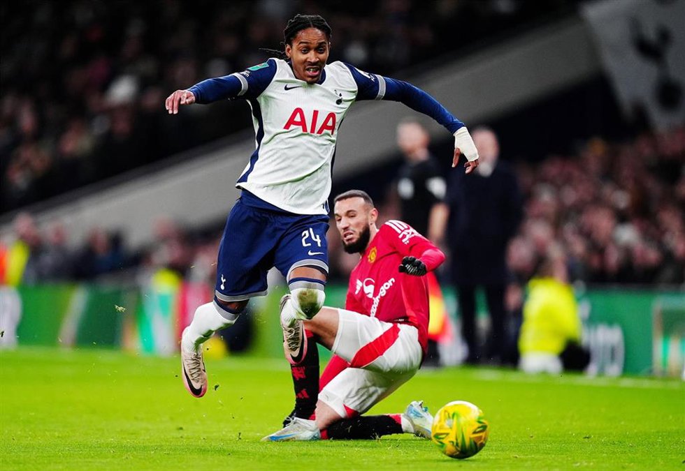 19 December 2024, United Kingdom, London: Tottenham Hotspur's Djed Spence (L) and Manchester United's Noussair Mazraoui battle for the ball during the English Carabao Cup quarter-final soccer match between Tottenham Hotspur and Manchester United at the