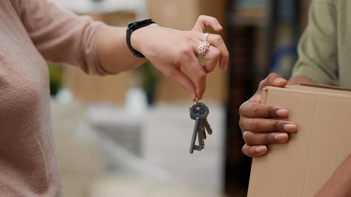 Archivo - Una mujer entrega las llaves de una vivienda