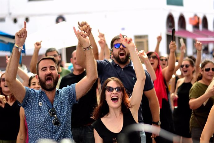 Público de un concierto con brazos en alto.